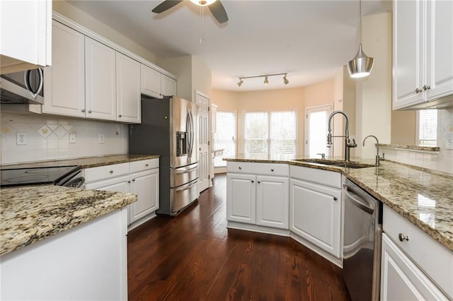 kitchen with sink, stainless steel appliances, hanging light fixtures, and white cabinetry