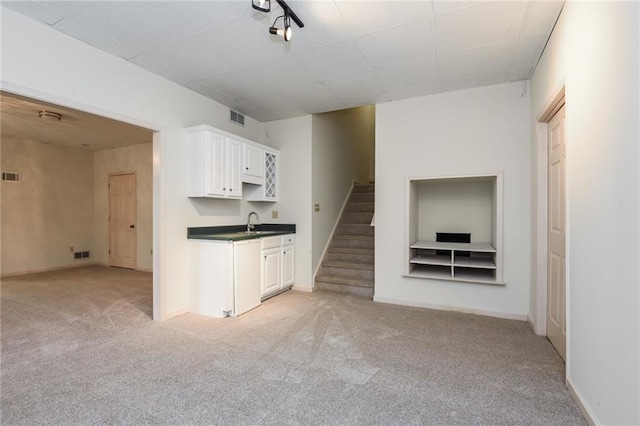 unfurnished living room featuring sink and light carpet