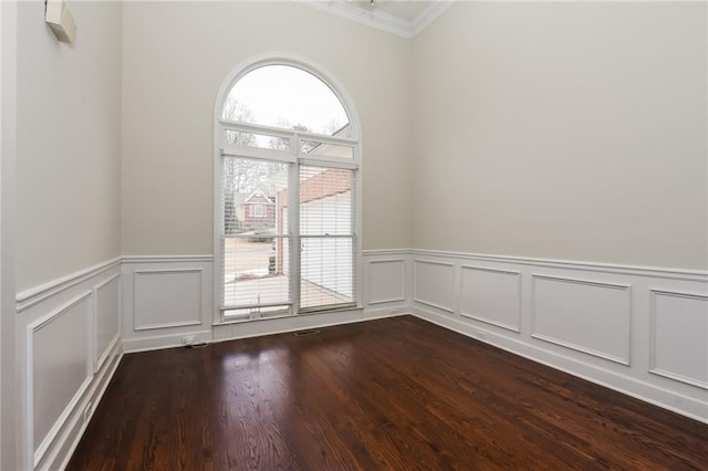 spare room with crown molding, a wealth of natural light, and wood-type flooring