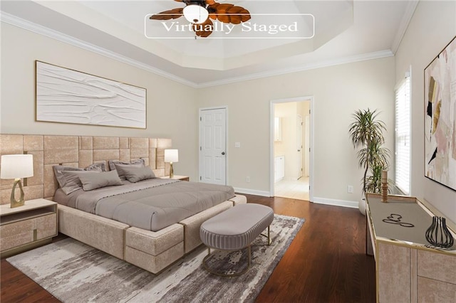 bedroom featuring ceiling fan, dark hardwood / wood-style flooring, ensuite bathroom, and a tray ceiling