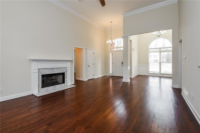 5055 Hickory Hills Dr, Woodstock, GA 30188 - unfurnished living room with ceiling fan with notable chandelier, a fireplace, crown molding, a towering ceiling, and dark wood-style flooring