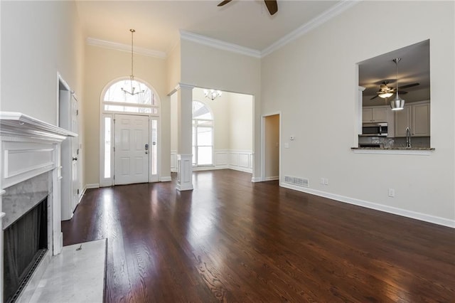 5055 Hickory Hills Dr, Woodstock, GA 30188 - entrance foyer with visible vents, ornamental molding, decorative columns, ceiling fan with notable chandelier, and wood finished floors