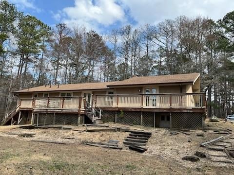 rear view of house featuring stairway and a wooden deck