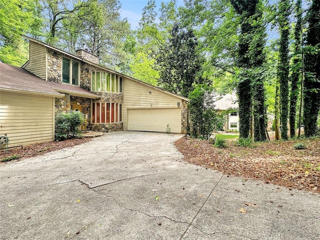 10320 Crescent Ridge Dr, Roswell, GA 30076 - view of side of home with stone siding, a chimney, driveway, and a garage