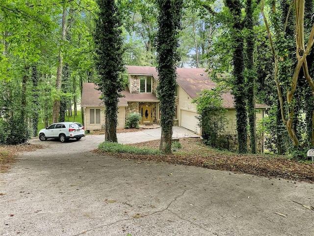 10320 Crescent Ridge Dr, Roswell, GA 30076 - view of property hidden behind natural elements featuring concrete driveway and a garage
