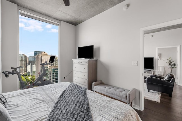 bedroom featuring ceiling fan, dark hardwood / wood-style floors, and multiple windows