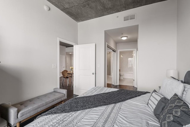 bedroom with dark hardwood / wood-style flooring and ensuite bathroom