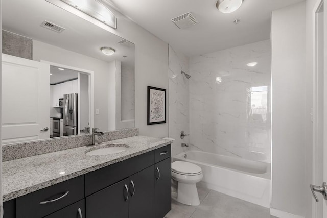 full bathroom featuring tile patterned flooring, toilet, vanity, and tiled shower / bath