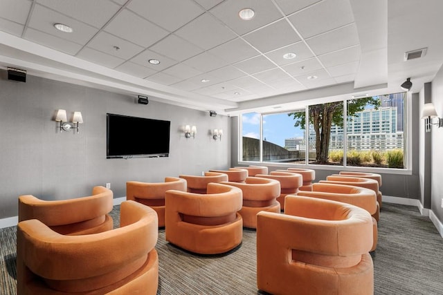 carpeted cinema room featuring a drop ceiling