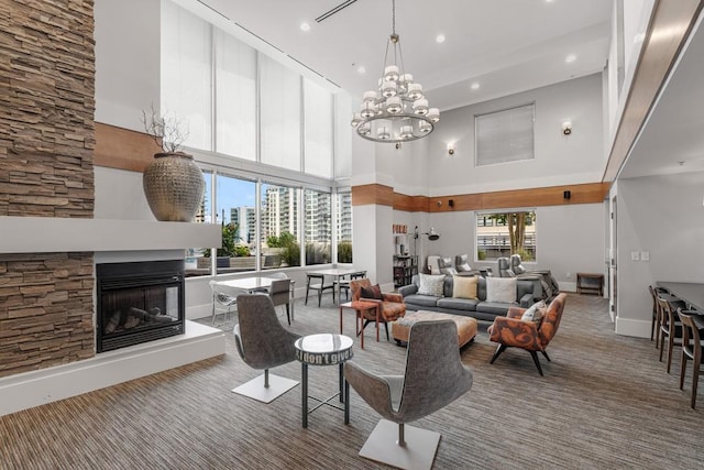 living room with a fireplace, a high ceiling, and an inviting chandelier