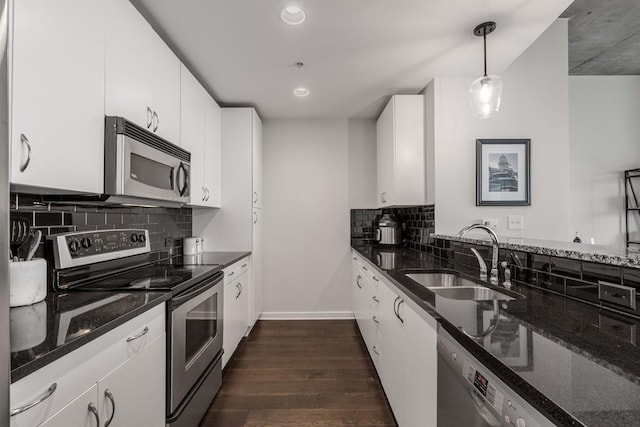 kitchen with sink, white cabinets, decorative light fixtures, and appliances with stainless steel finishes