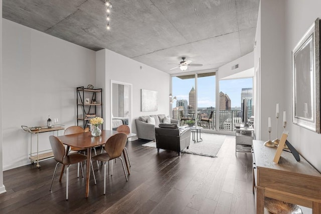 dining space featuring dark hardwood / wood-style floors, a wall of windows, and ceiling fan