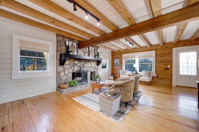 923 Pine Cir, Woodstock, GA 30189 - living area featuring light wood-style floors, track lighting, beamed ceiling, wooden walls, and healthy amount of natural light