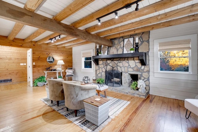 living room with beam ceiling, track lighting, wooden walls, and wood-type flooring