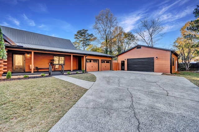 view of front facade with an outbuilding, a front lawn, a porch, and a garage