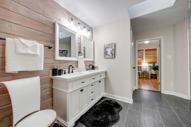 bathroom with tile patterned floors, vanity, and wood walls