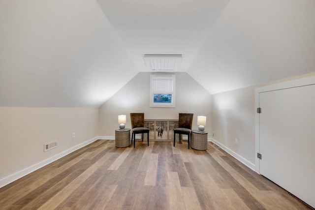 living area with light hardwood / wood-style floors and lofted ceiling