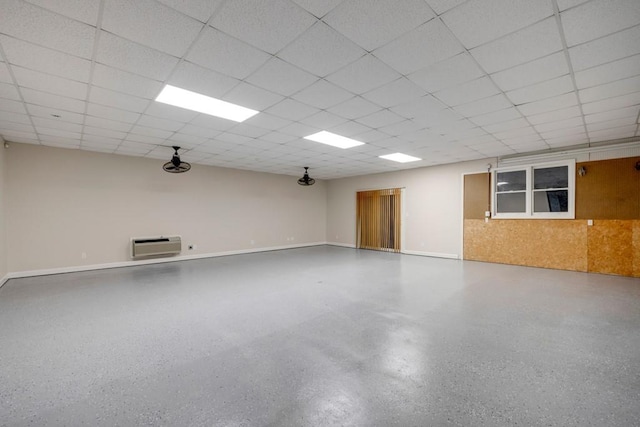 empty room featuring a wall mounted air conditioner and a drop ceiling