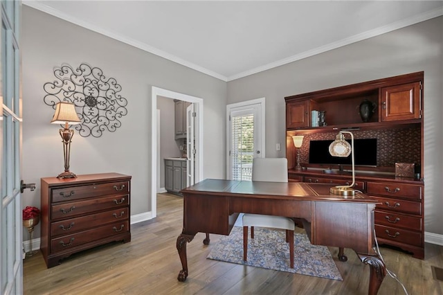 office with light wood-style floors, baseboards, and ornamental molding