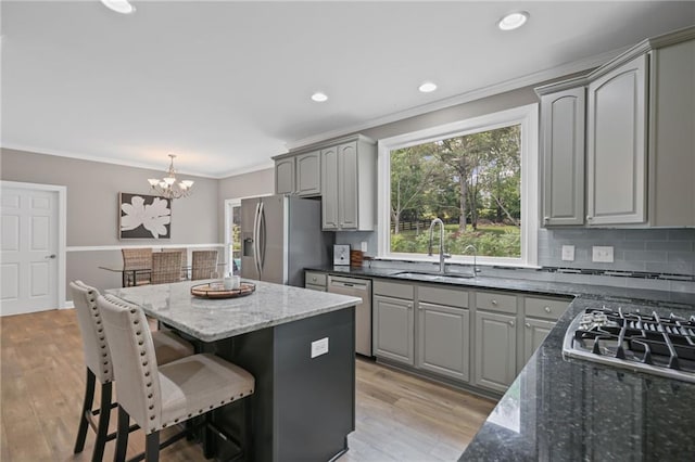 kitchen with gray cabinetry, a notable chandelier, appliances with stainless steel finishes, and a sink