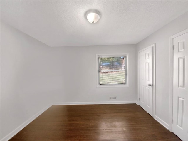 1879 Shamrock Dr, Decatur, GA 30032 - unfurnished bedroom featuring baseboards, visible vents, dark wood-type flooring, and a textured ceiling