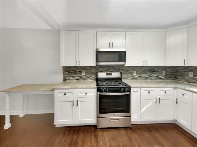 1879 Shamrock Dr, Decatur, GA 30032 - kitchen with light countertops, stainless steel appliances, tasteful backsplash, and dark wood finished floors