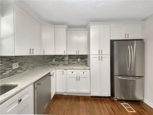 1879 Shamrock Dr, Decatur, GA 30032 - kitchen featuring white cabinetry, tasteful backsplash, dark wood-style floors, visible vents, and appliances with stainless steel finishes