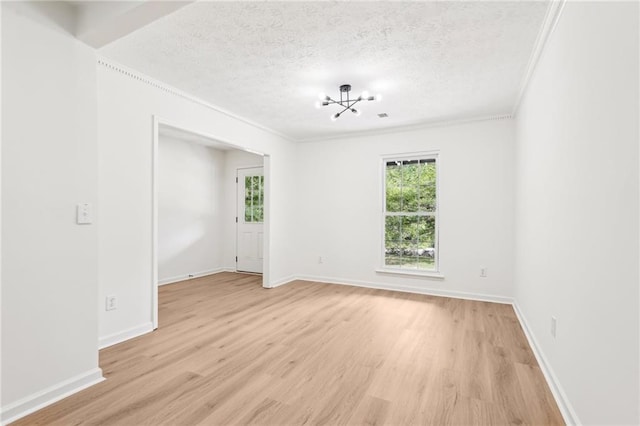 unfurnished room featuring light wood-style floors, a textured ceiling, baseboards, an inviting chandelier, and ornamental molding