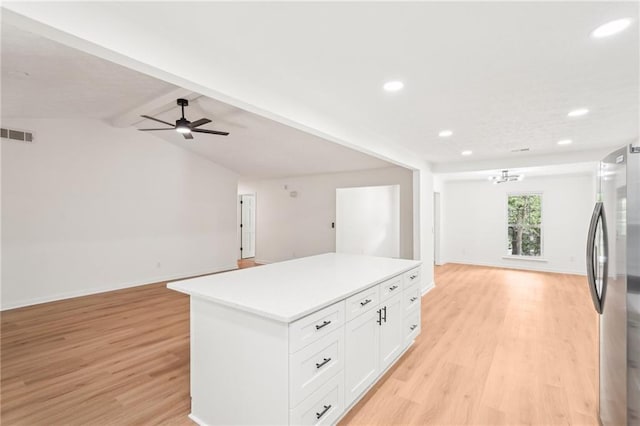 kitchen with light wood-style floors, open floor plan, a kitchen island, and freestanding refrigerator