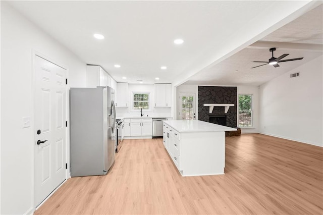 kitchen featuring ceiling fan, visible vents, light wood-style flooring, stainless steel appliances, and white cabinetry