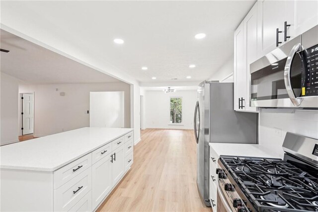 kitchen with a center island, light countertops, stainless steel appliances, recessed lighting, and light wood-style flooring