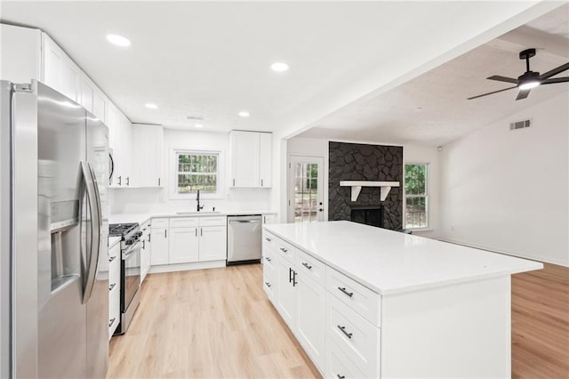 kitchen with light wood-style flooring, appliances with stainless steel finishes, a sink, and visible vents