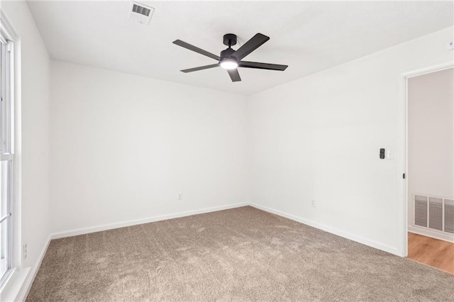 unfurnished room featuring carpet flooring, a ceiling fan, baseboards, and visible vents