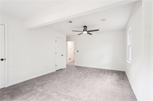 spare room featuring carpet floors, ceiling fan, visible vents, and baseboards