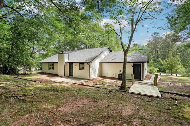 rear view of property with a patio and a shingled roof