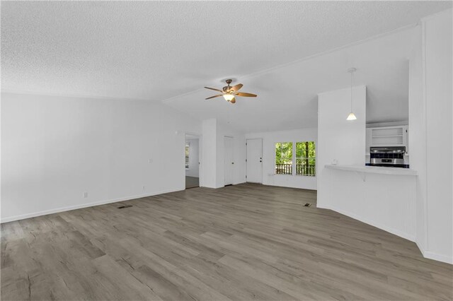 1437 Frank Lovell Rd, Clarkesville, GA 30523 - unfurnished living room featuring a ceiling fan, a textured ceiling, wood finished floors, and vaulted ceiling