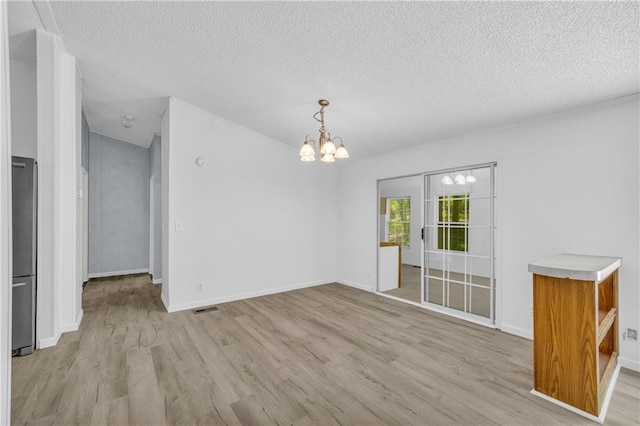 1437 Frank Lovell Rd, Clarkesville, GA 30523 - unfurnished dining area with a textured ceiling, a chandelier, light wood-style flooring, baseboards, and visible vents