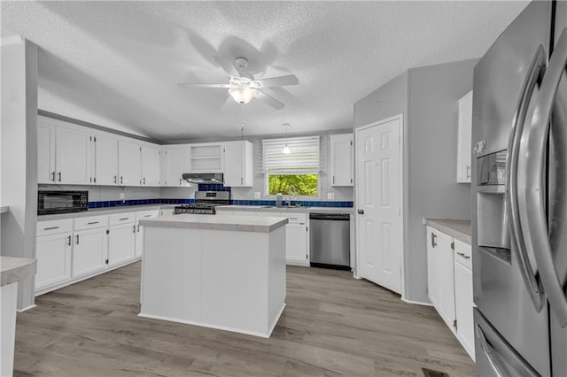 1437 Frank Lovell Rd, Clarkesville, GA 30523 - kitchen with a ceiling fan, appliances with stainless steel finishes, white cabinets, under cabinet range hood, and light wood-style flooring