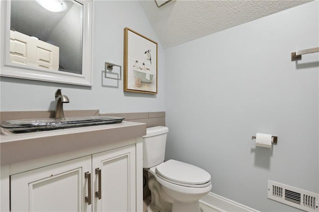 210 N Wesleyan Cir, Macon, GA 31210 - bathroom featuring vanity, lofted ceiling, and a textured ceiling