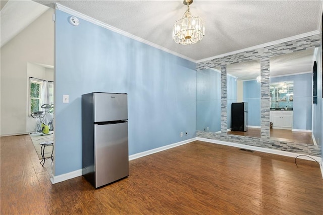 210 N Wesleyan Cir, Macon, GA 31210 - unfurnished dining area featuring crown molding, wood finished floors, a textured ceiling, a chandelier, and ornate columns