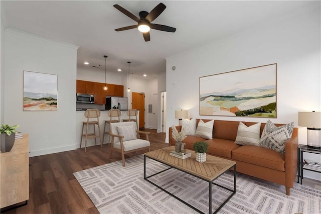living area with ceiling fan, crown molding, wood finished floors, baseboards, and recessed lighting