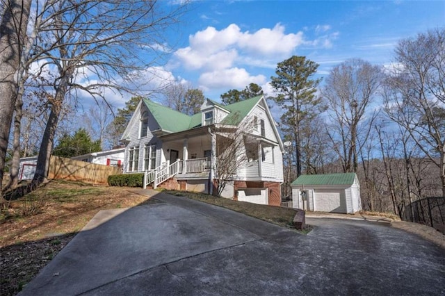 view of home's exterior with an outbuilding, covered porch, and a garage