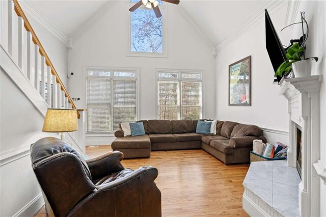 living room featuring a wealth of natural light, ceiling fan, light hardwood / wood-style flooring, and ornamental molding