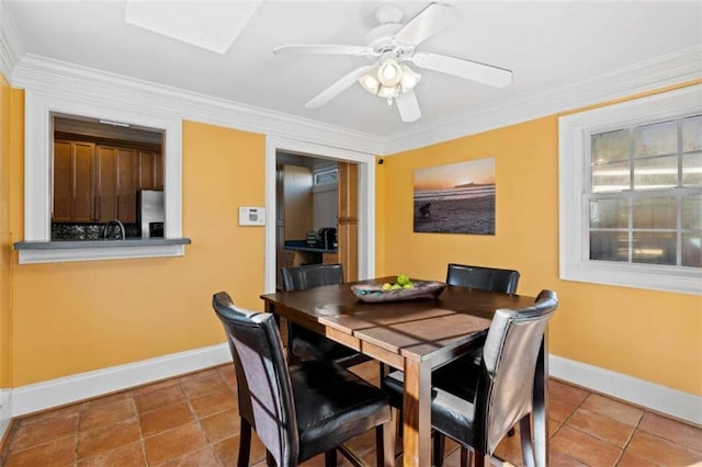 tiled dining space featuring ceiling fan and ornamental molding