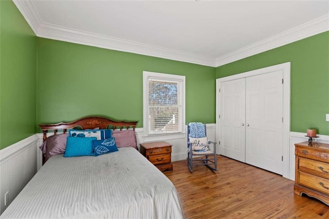 bedroom featuring a closet, crown molding, and light hardwood / wood-style flooring