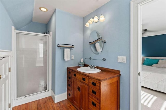 bathroom featuring hardwood / wood-style floors, vanity, a shower with shower door, and vaulted ceiling