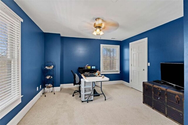 carpeted office featuring ceiling fan