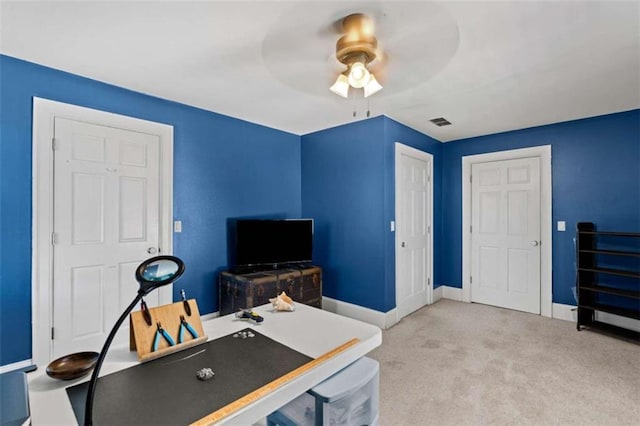 carpeted home office featuring ceiling fan