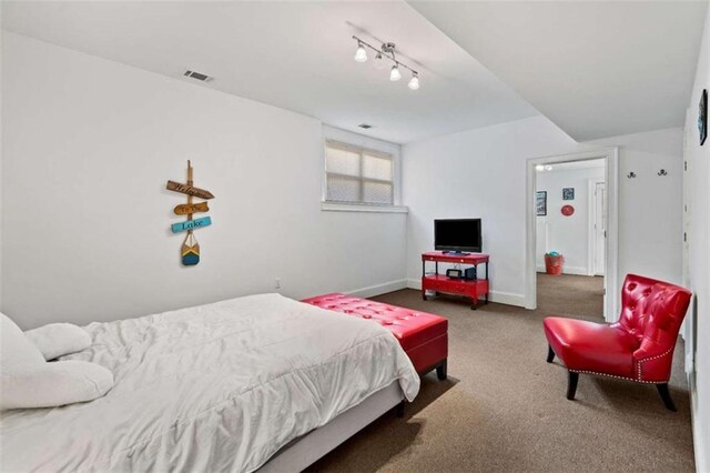 carpeted bedroom featuring rail lighting