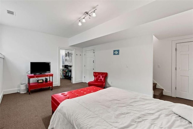 carpeted bedroom featuring rail lighting